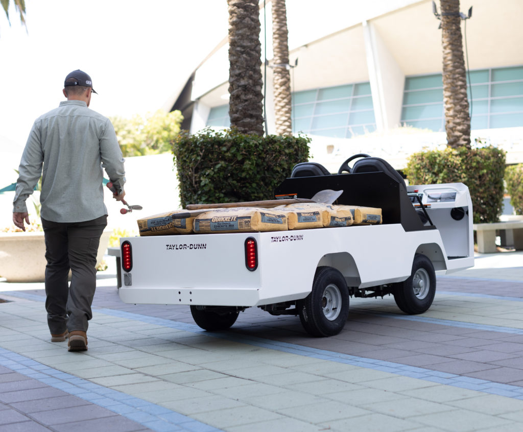 Man walking up to a utility vehicle loaded with concrete mix