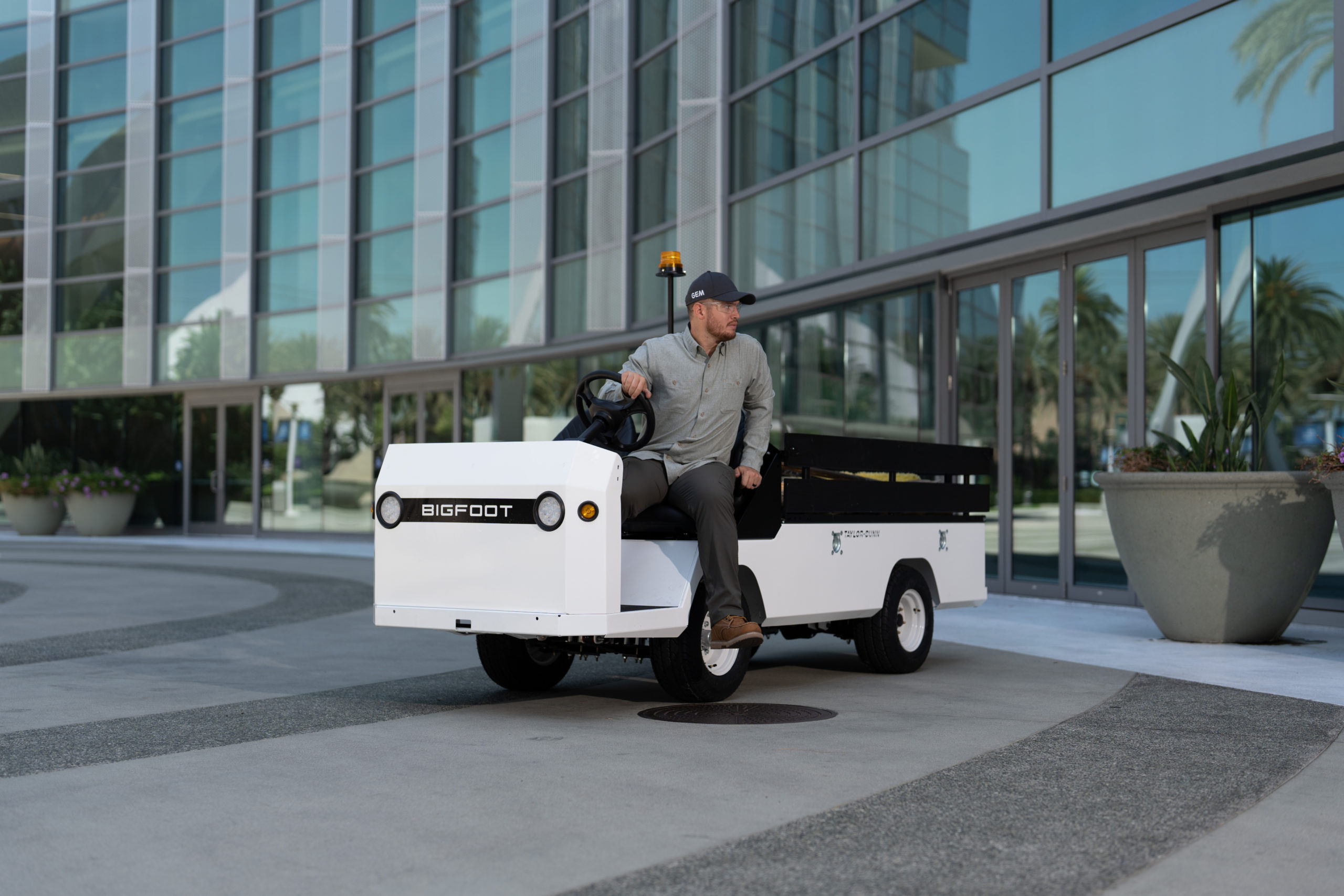 Man on exiting a white utility vehicle outside of a building