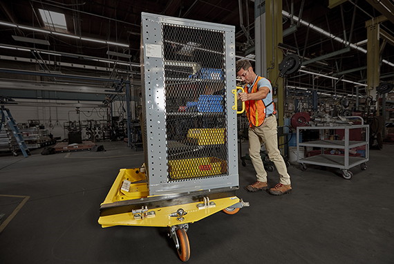 Man moving large cage in warehouse